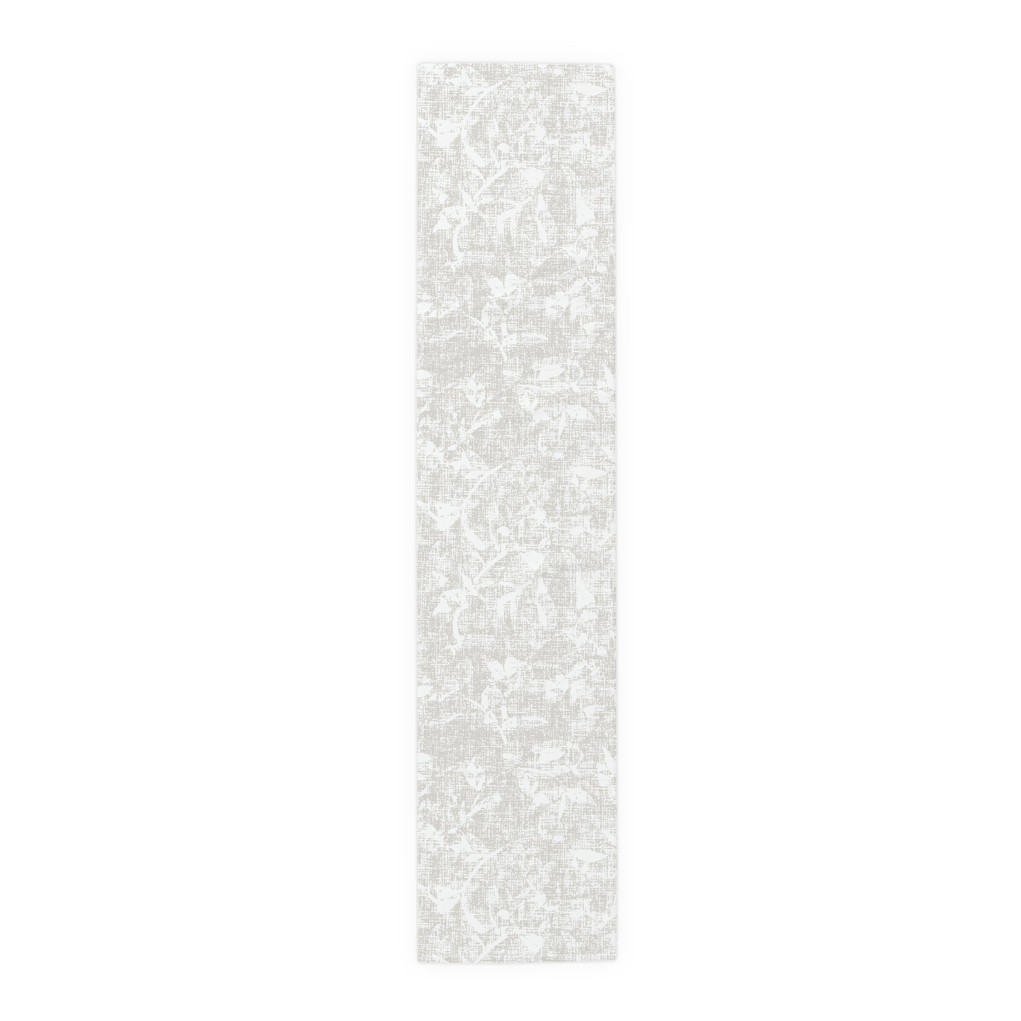 Soft, understated neutral botanical table runner with a subtle floral motif in muted gray.
