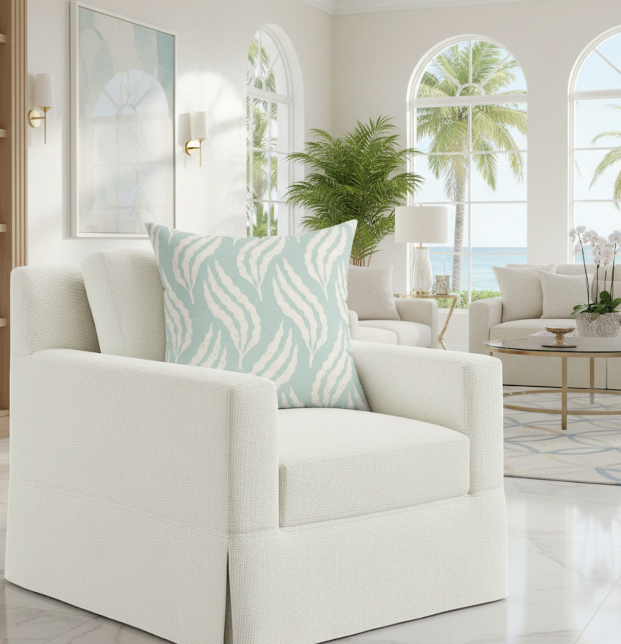 Aqua Leaf Pattern Throw Pillow on a white textured armchair in a coastal, modern living room.